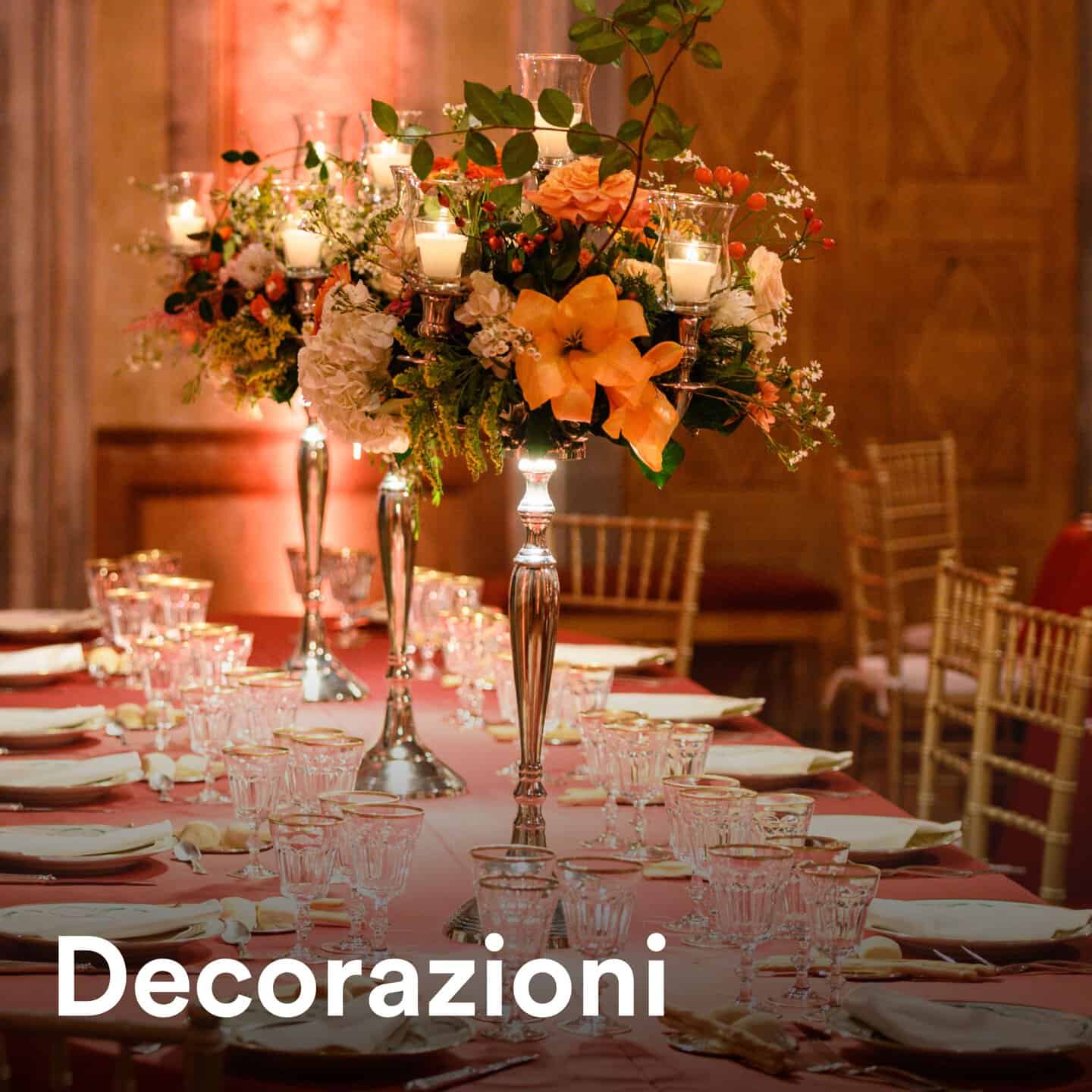 Decorazioni floreali eleganti con candele su tavolo da evento, atmosfera raffinata e accogliente.