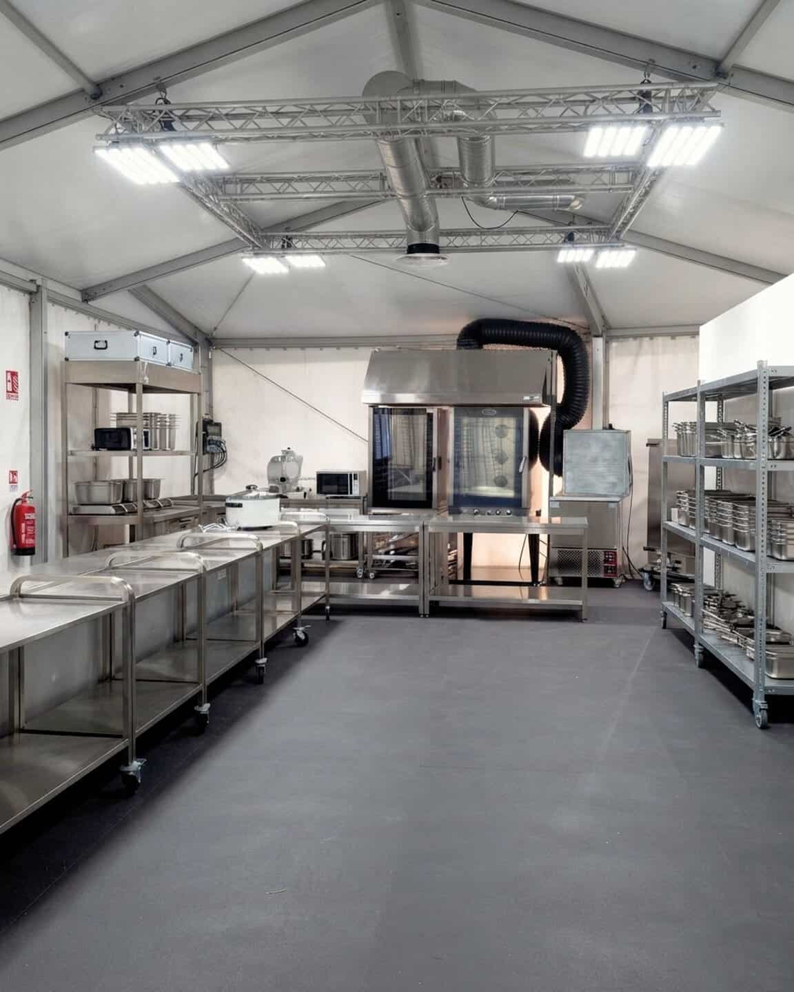 Laboratorio di cucina professionale con attrezzature in acciaio inox e sistemi di ventilazione avanzati.