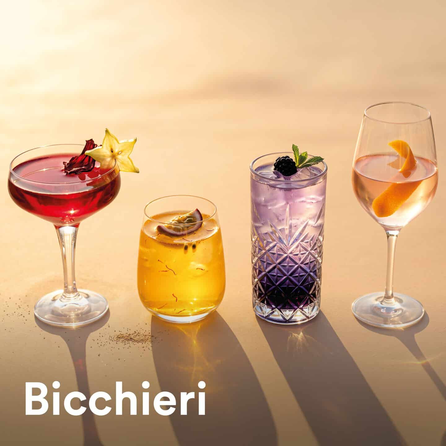Quattro bicchieri di cocktail colorati e decorati, disposti su una superficie luminosa, rappresentano una selezione di bevande eleganti e rinfrescanti.