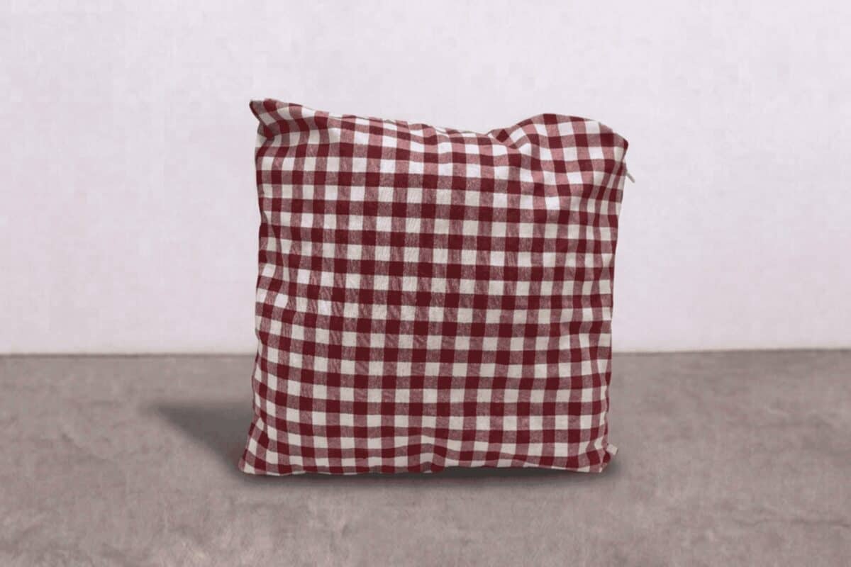 Cuscino decorativo con fantasia a quadri rosso e bianco, ideale per arredamento di interni.