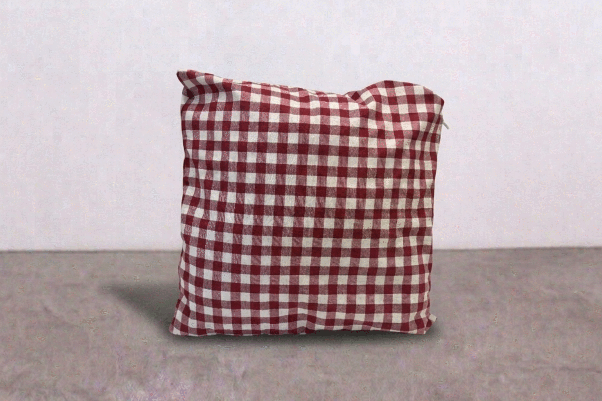 Cuscino a scacchi di colore bordeaux e bianco con lunghezza 45 per 45 centimetri.