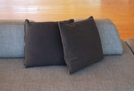 Cuscino 50x50 cm antracite su divano moderno, ideale per arredo elegante e confortevole.