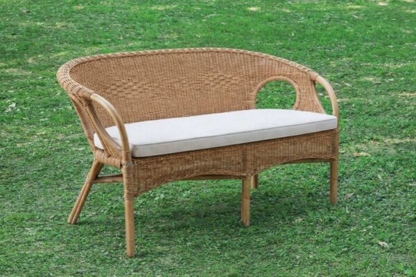 Noleggio divano in vimini con cuscino ecrù, perfetto per esterni e giardini.