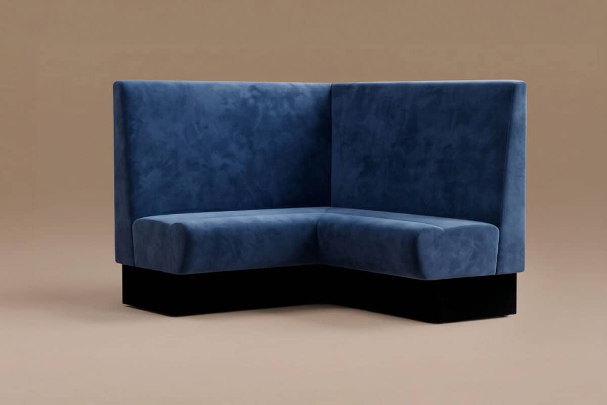Divano angolare in velluto blu scuro con schienale alto, ideale per arredare soggiorni eleganti e moderni.