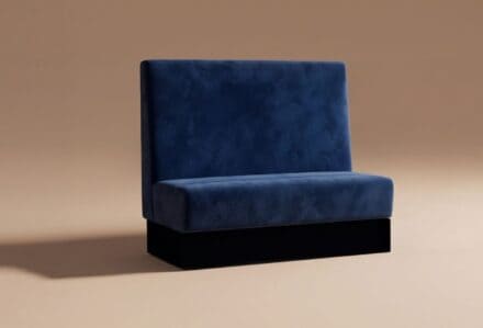 Divano moderno in velluto blu con schienale alto, ideale per arredare salotti eleganti e contemporanei.