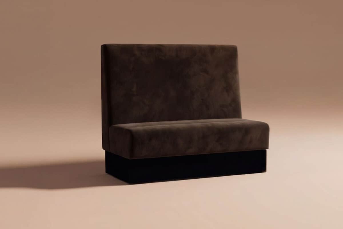 Divano nero in velluto con schienale alto, stile moderno, su sfondo neutro, ideale per arredamento di interni eleganti e contemporanei.