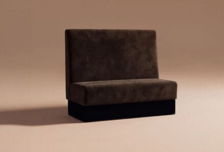 Divano nero in velluto con schienale alto, stile moderno, su sfondo neutro, ideale per arredamento di interni eleganti e contemporanei.