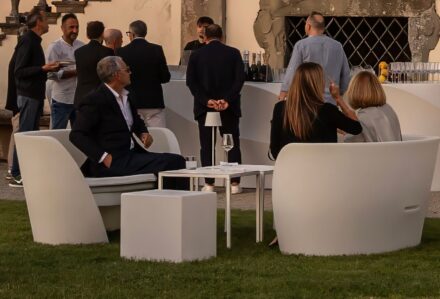 Gruppo di persone che socializzano e si rilassano all'aperto con arredi moderni di Modorent in un ambiente elegante.