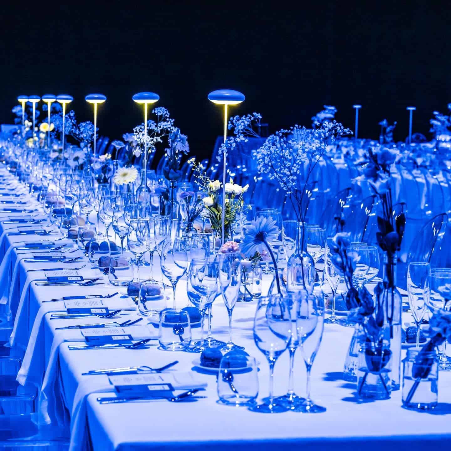 Tavola elegante all'aperto con illuminazione soffusa e decorazioni floreali, perfetta per eventi speciali e matrimoni in Italia.