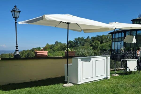 Tavolo con ombrellone e sedie in giardino con vista panoramica, ideale per eventi e feste all'aperto.