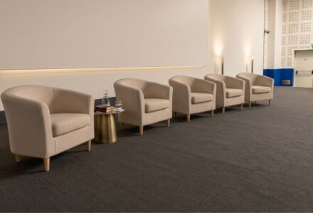 Poltrona Ios in tessuto beige con braccioli morbidi, ideale per ambienti di attesa o sale riunioni, con design elegante e confortevole, perfetta per arredare con stile.
