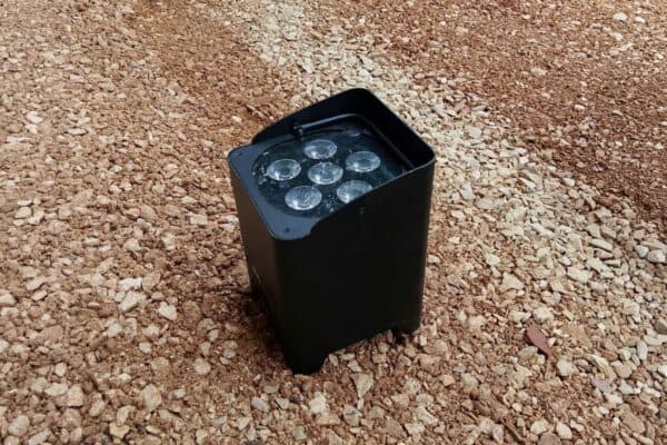 Faro di segnalazione a LED nero posizionato su terreno di ghiaia.