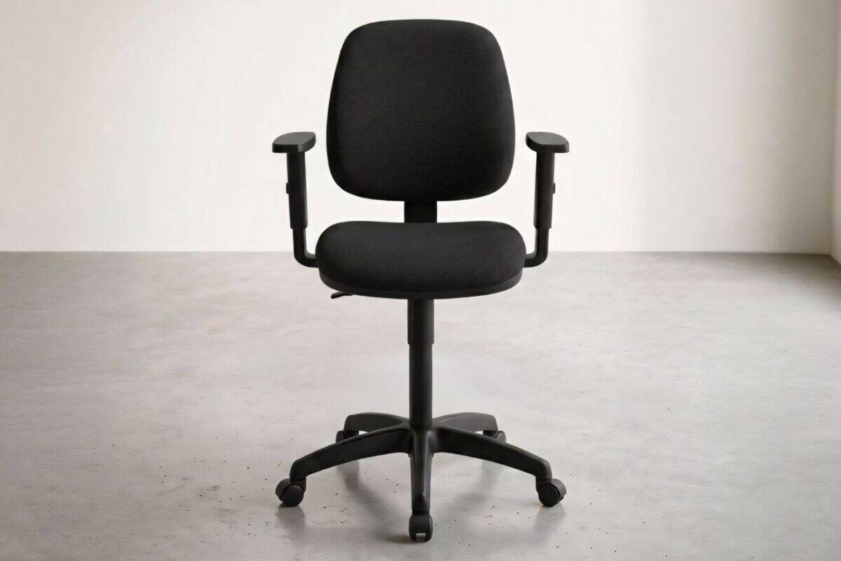 Sedia da ufficio nera con braccioli regolabili in un ambiente minimalista luminoso.