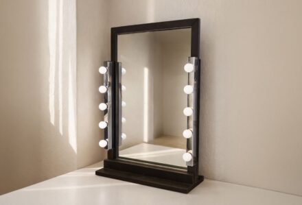 Specchio da trucco con luci a LED, ideale per make-up e skincare, posizionato su una parete neutra.