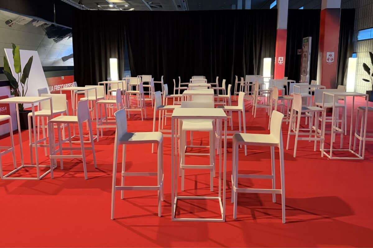 Tavolino mangia-in-piedi con struttura in metallo verniciato di colore bianco, con certificazione ignifuga classe 1, idonea per eventi, fiere e congressi.