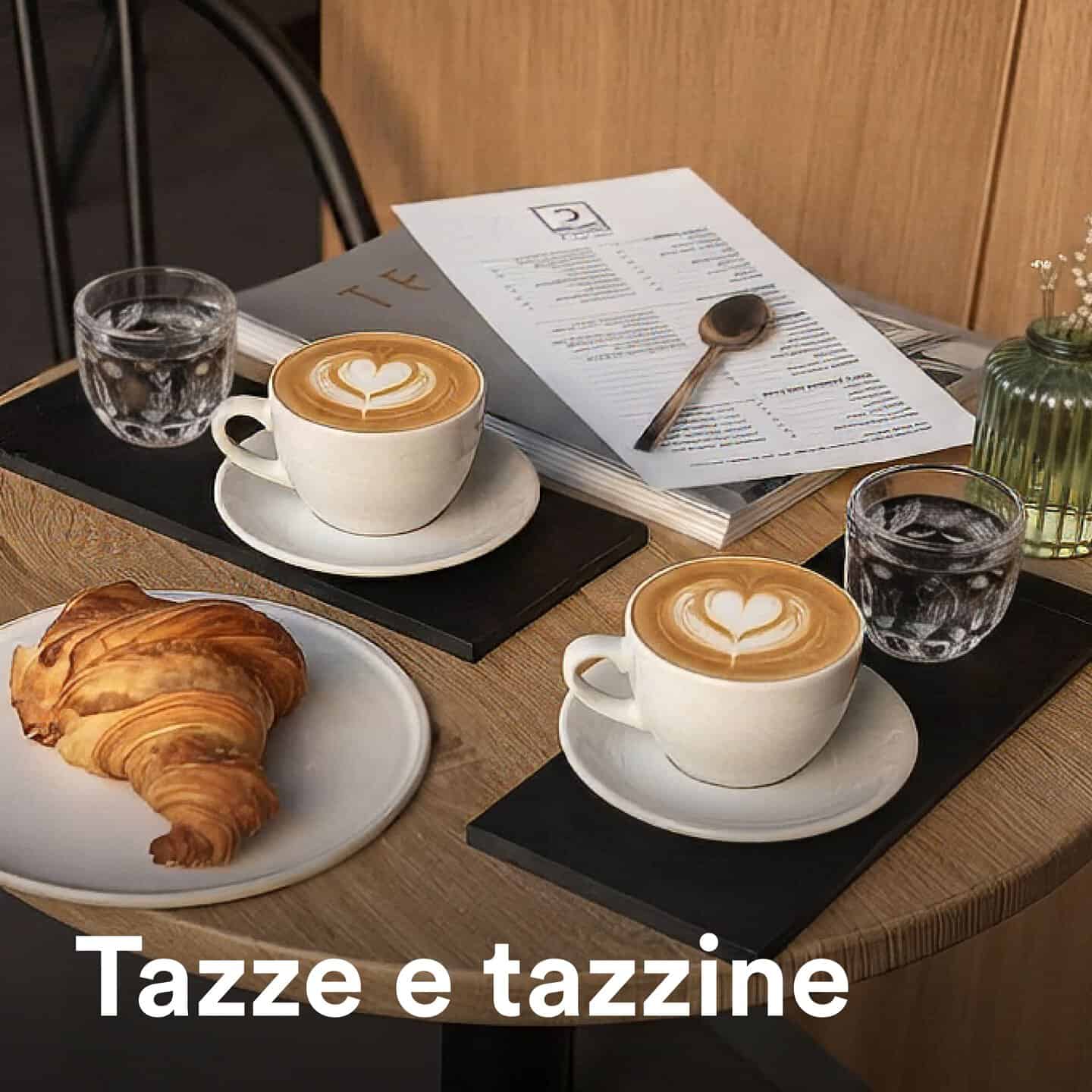 Tazze di caffè con latte art, croissant e acqua in un bar accogliente, perfetto per colazioni e pause rilassanti.