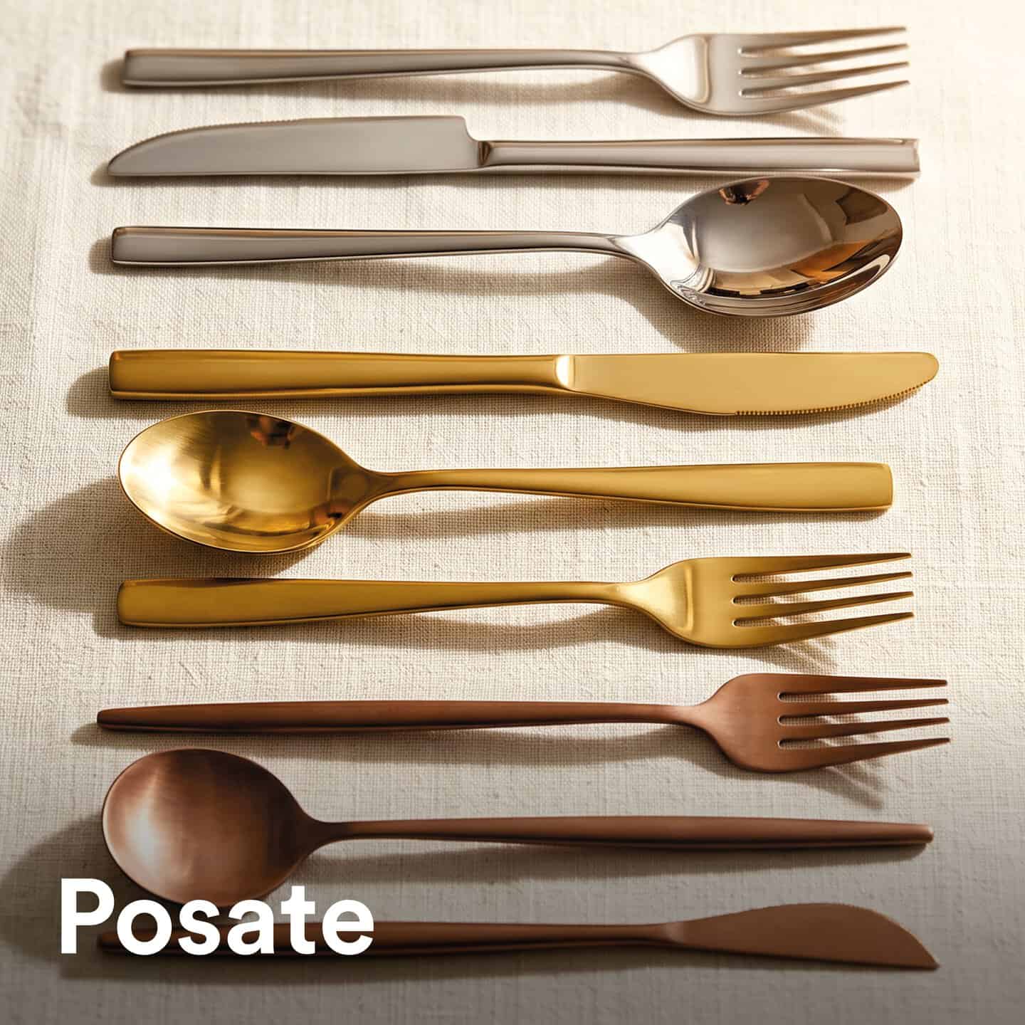 Set di posate eleganti in vari colori e finiture su tovaglia di lino, ideale per tavole raffinate e di classe.